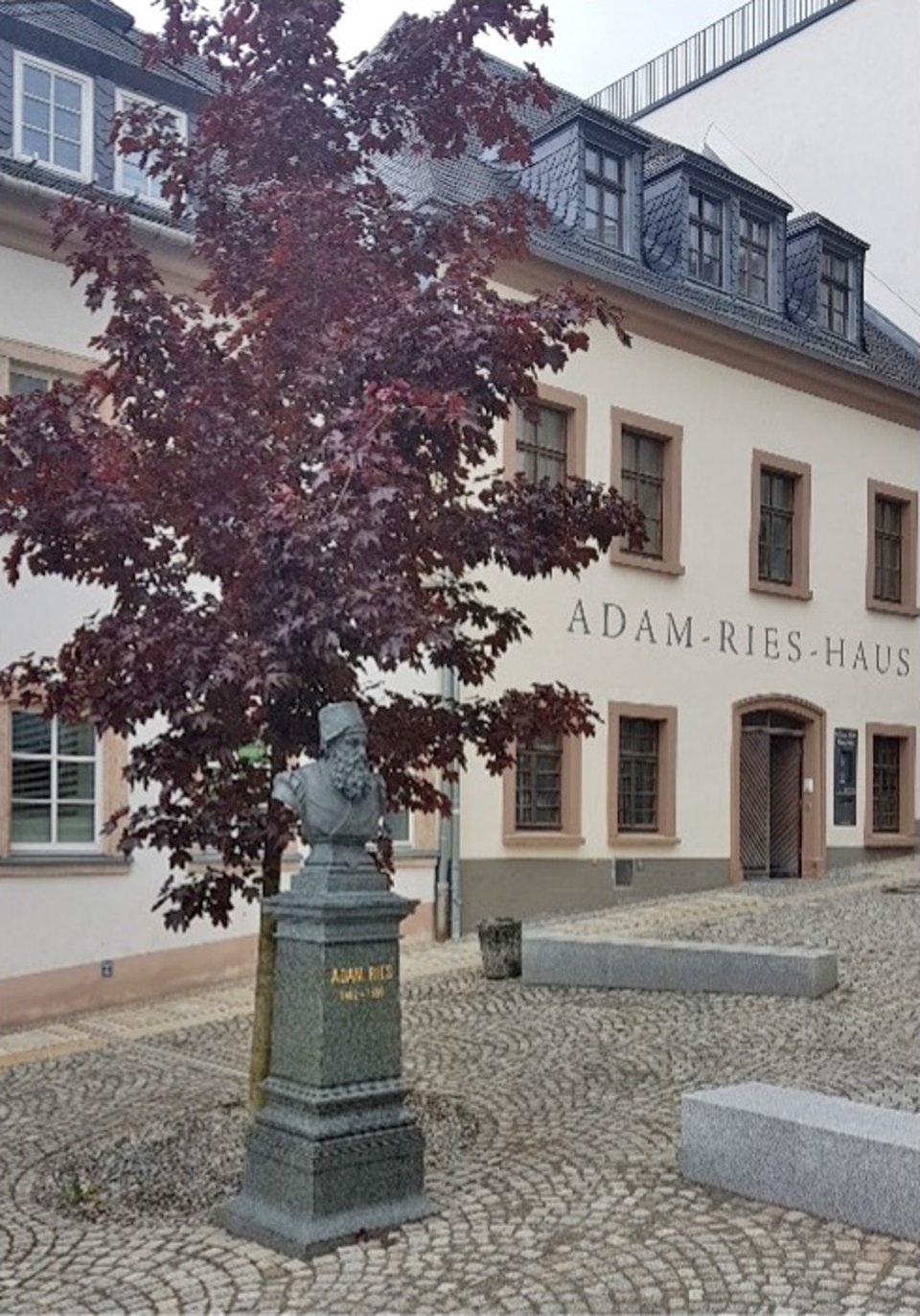Blick auf das Adam-Ries-Haus mit Denkmal des Rechenmeisters